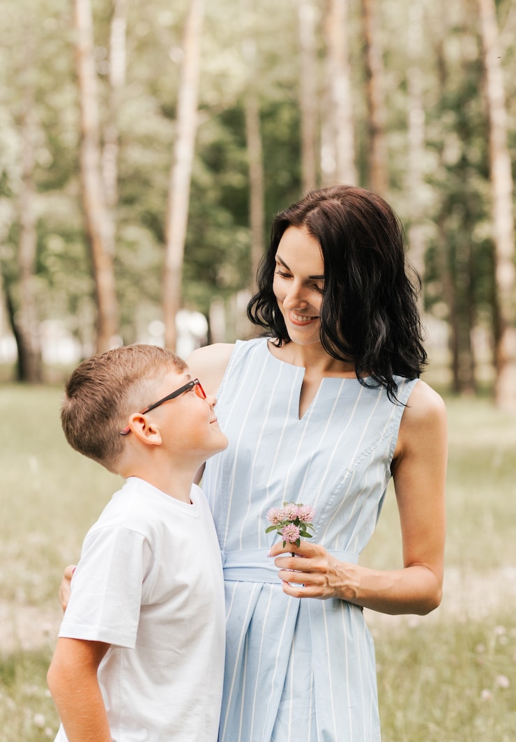 Photo young mother with her son in the park in the summer. happy family walk in the park.