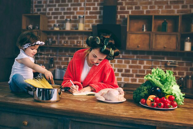 Young mother with little child in the home kitchen