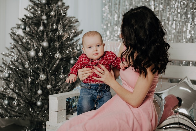 Young mother with newborn boy son sitting 