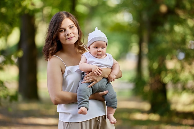 Young mother with nursing baby in her arms in public park