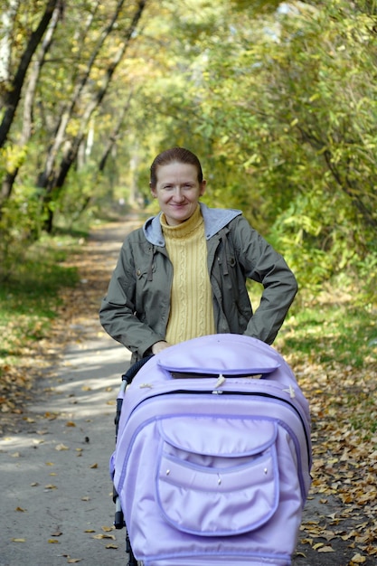 Photo young mother with perambulator