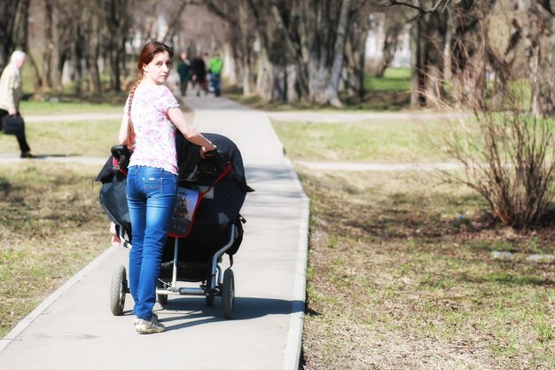 公園でベビーカーを持つ若い母親