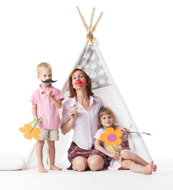 Young mother with two children on white happy smiling family inside