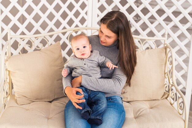 Young mother woman holding and hugging in her arms child baby kid girl smilling laughing.