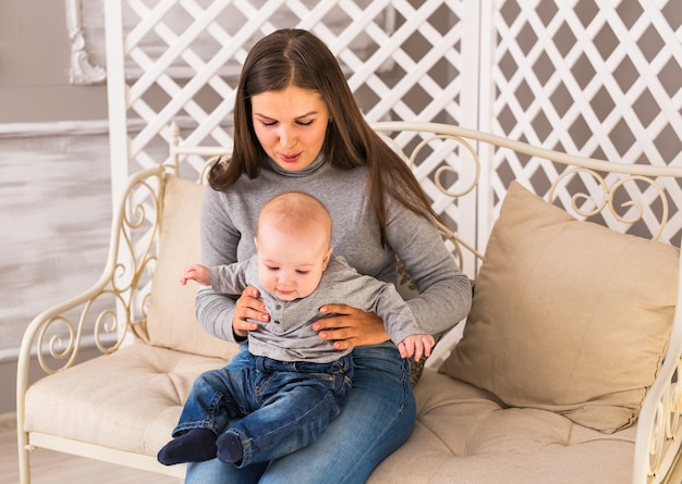 Young mother woman holding and hugging in her arms child baby kid girl smilling laughing.