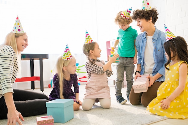 Giovani madri che giocano con i bambini alla festa di compleanno