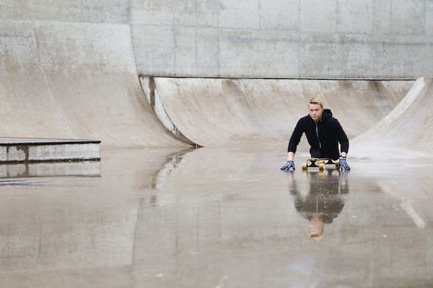 Young and motivated handicapped  guy with a longboard in the skatepark