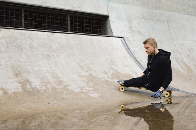 Young and motivated handicapped  guy with a longboard in the skatepark