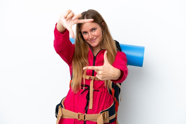 Young mountaineer girl with a big backpack over isolated white background focusing face Framing symbol