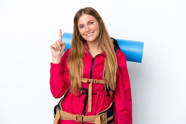 Young mountaineer girl with a big backpack over isolated white background showing and lifting a finger in sign of the best