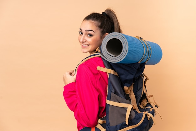 大きなバックパッカーを持つ若い登山家の女の子