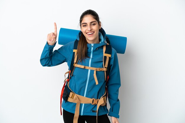 Young mountaineer man with a big backpack over isolated background pointing up a great idea