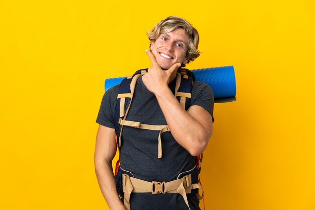 Young mountaineer man over yellow happy and smiling