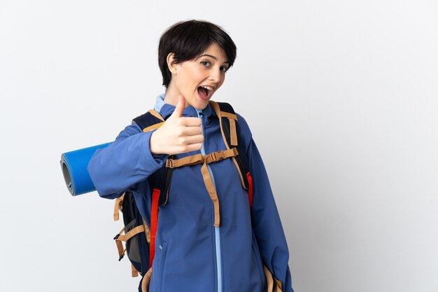 Young mountaineer woman over isolated space with thumbs up because something good has happened