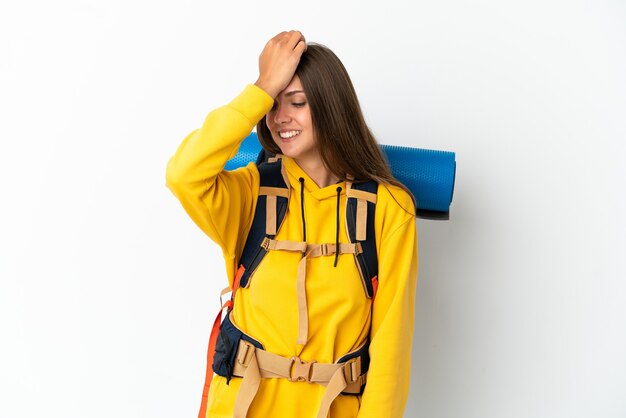 Young mountaineer woman with a big backpack over isolated white background has realized something and intending the solution