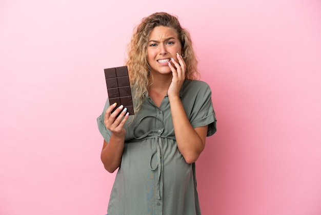 Young mountaineer woman with a big backpack isolated on yellow background surprised and shocked while looking right