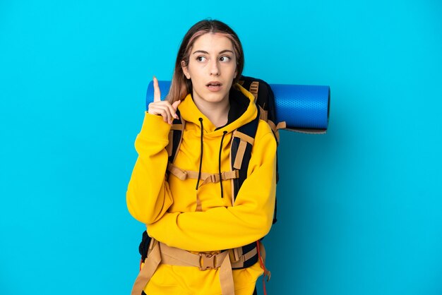 Young mountaineer woman with a big backpack isolated