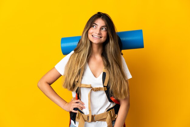 Young mountaineer woman with a big backpack isolated