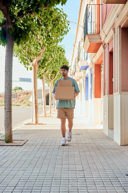 彼の手に箱を持つ若い動く男