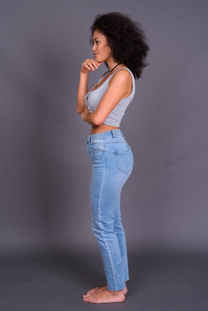  young multi ethnic African American woman with Afro hair against gray wall