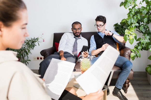 Young multi-ethnic businessmen watching video on phone