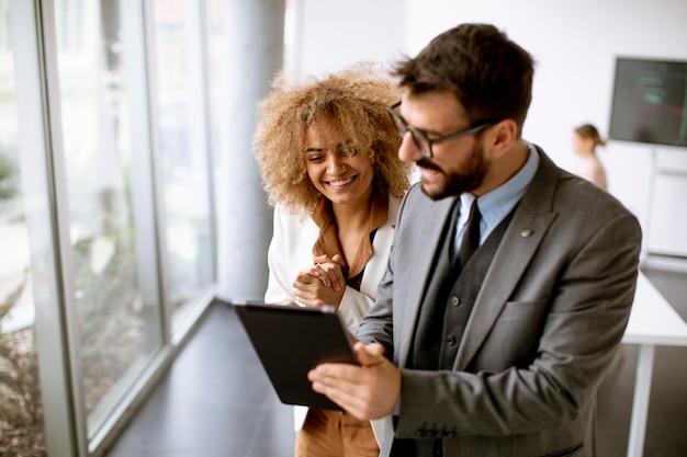 Young multiethnic entrepreneurs standing together and talking in the modern office