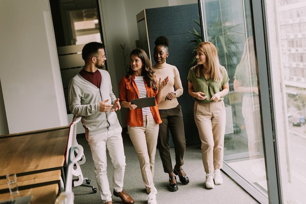 Young multiethnic startup team walking at the modern office