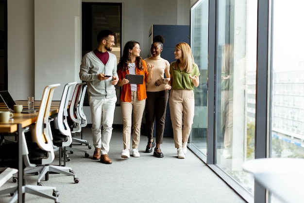 Young multiethnic startup team walking at the modern office