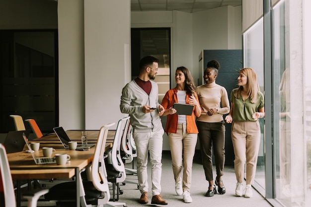 Photo young multiethnic startup team walking at the modern office