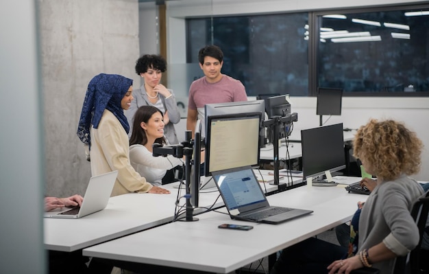 young multiethnics business team of software developers working together using laptop computer while writing programming code at modern startup office