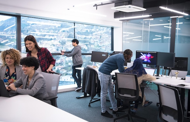 young multiethnics business team of software developers working together using laptop computer while writing programming code at modern startup office