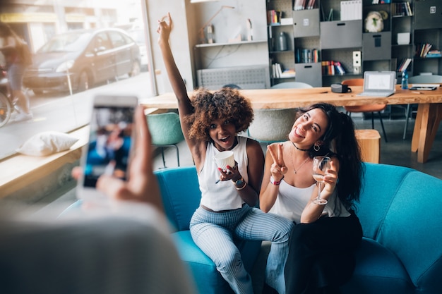 young multiracial women taking photo and having fun in modern pub 