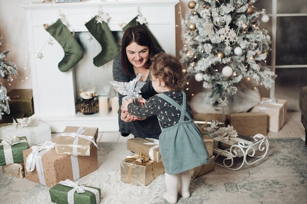 Young mum unpacks a lot of presents with her pretty daighter