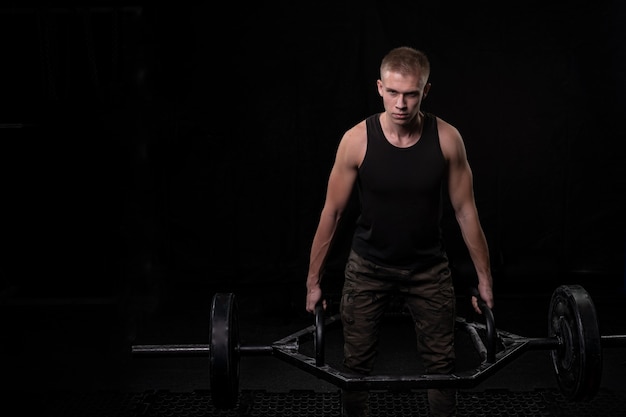 Young muscular athlete in training in the gym