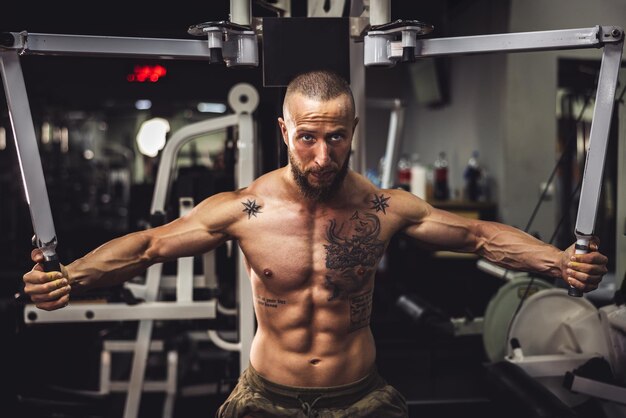 a young muscular bodybuilder man doing hard training for his chest muscles at the gym.