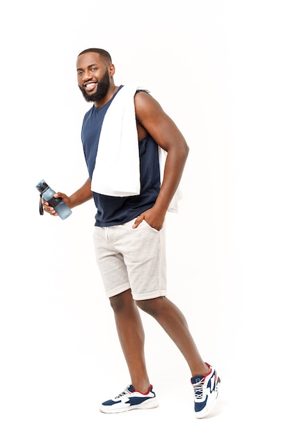 Молодой мускулистый мужчина держит воду в бутылке после бега, привлекательный спортсмен отдыхает после тренировки на открытом воздухе, фитнеса и концепции здорового образа жизни. Изолированные на белом.