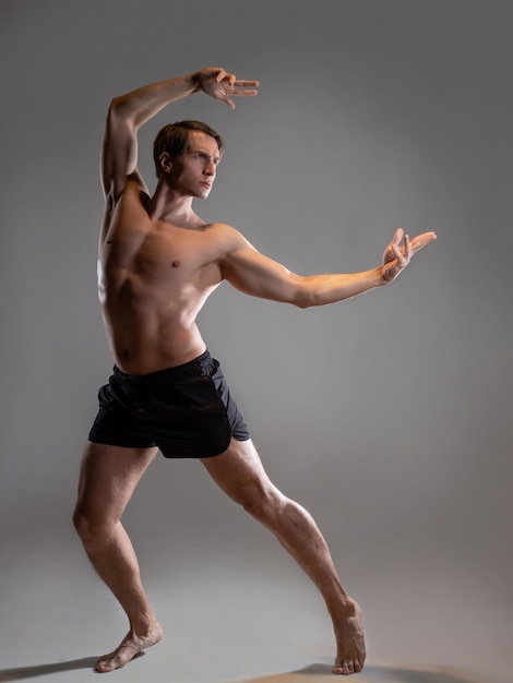 Photo young muscular man in an expressive pose artistic pose of the hero with outstretched arms beautiful