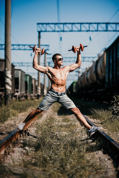 Young muscular man goes in for sports on the street young\
strong sportsman training