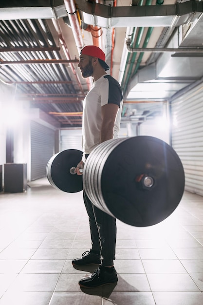 Young muscular man ready to deadlift exercise at the garage gym.