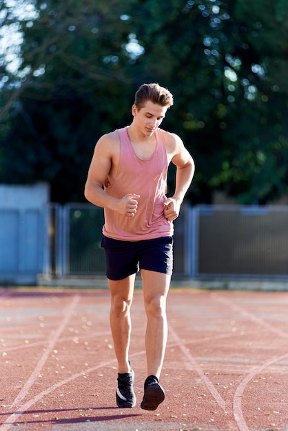 Young muscular man running on the track