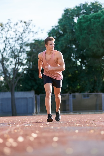 Young muscular man running on the track