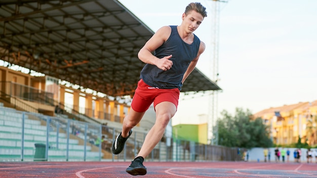 Young muscular man running on the track