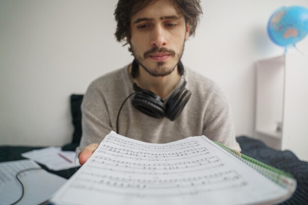 Young musician man composing music at home