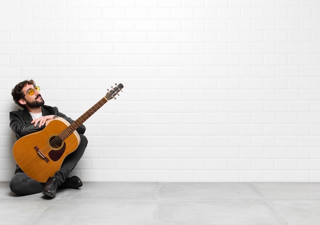 Young musician man feeling happy with a guitar