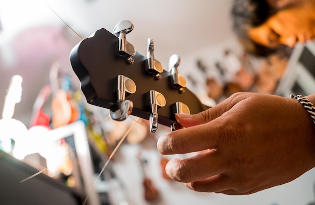 Young musician tuning a classical guitar in a guitar shop