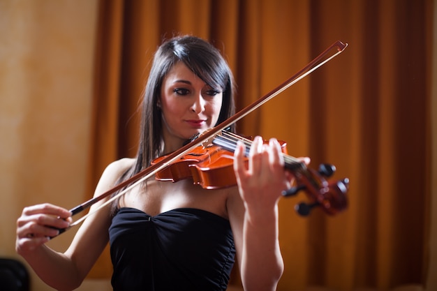 Young musician woman playing her violin