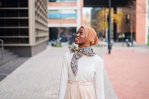 Young muslim black woman in hijab looking up