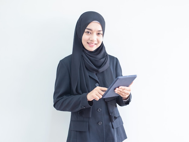 Молодая мусульманская бизнес-леди держа таблетку