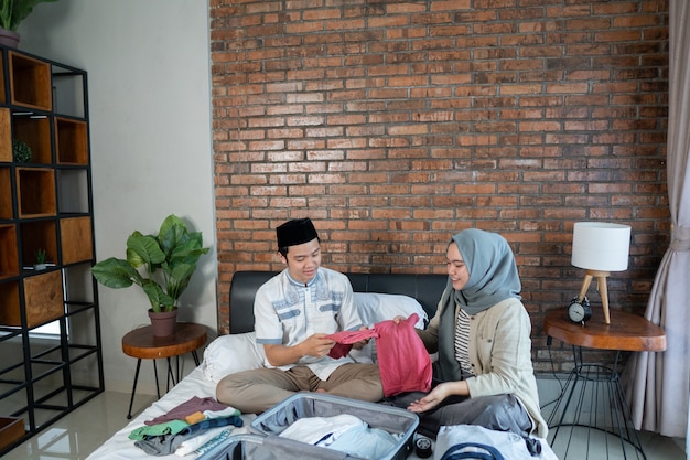 Young Muslim couple prepare luggage together