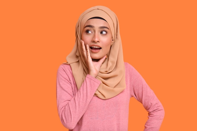 young muslim girl wearing posing over orange background india pakistani model